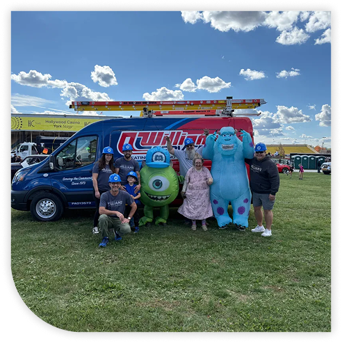 image of team wearing blue hard hats in front of work van next to monsters inc characters 